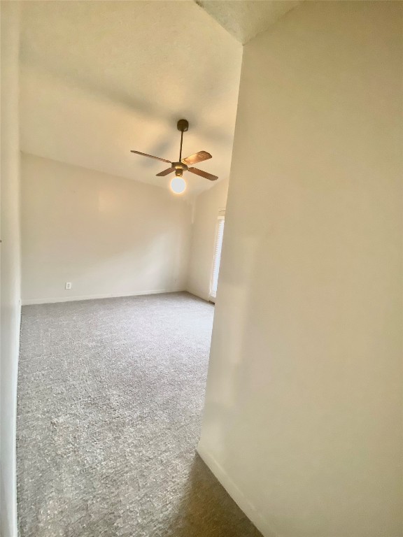 2216 San Gabriel Street, Unit 304 Austin, TX 78705 - Photo 6 of 24 Spare room featuring a ceiling fan, carpet flooring, lofted ceiling, and baseboards