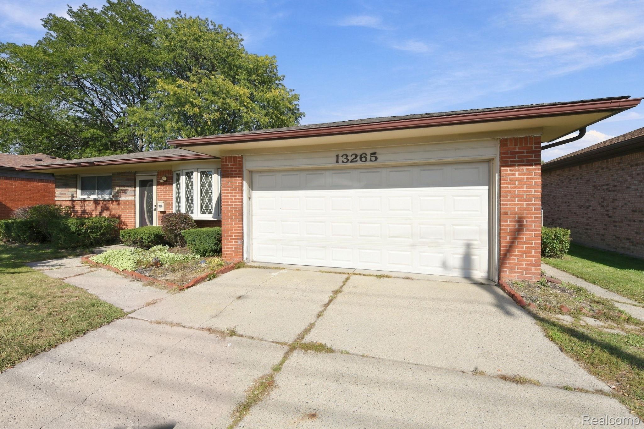 13265 12 Mile Road Warren, MI 48088 - Photo 2 of 33 Attached two-car garage, brick exterior, front entry door, bay window, and concrete driveway