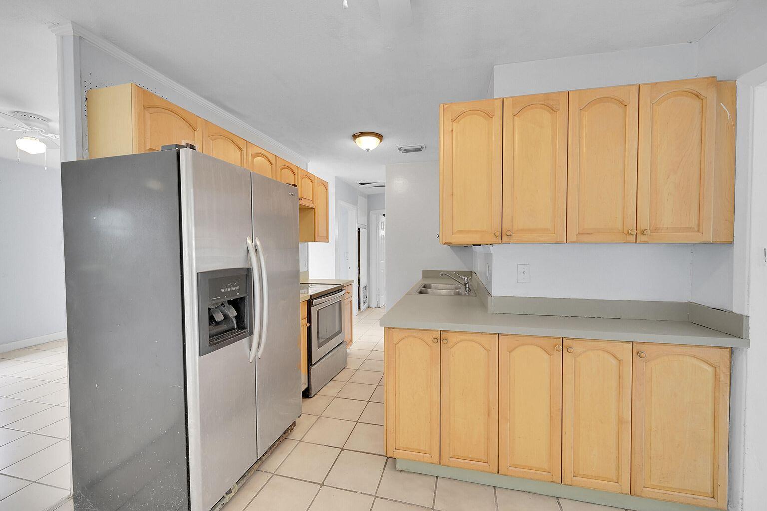 1645 West 31st Street Riviera Beach, FL 33404 - Photo 2 of 20 a kitchen with a refrigerator a sink and cabinets
