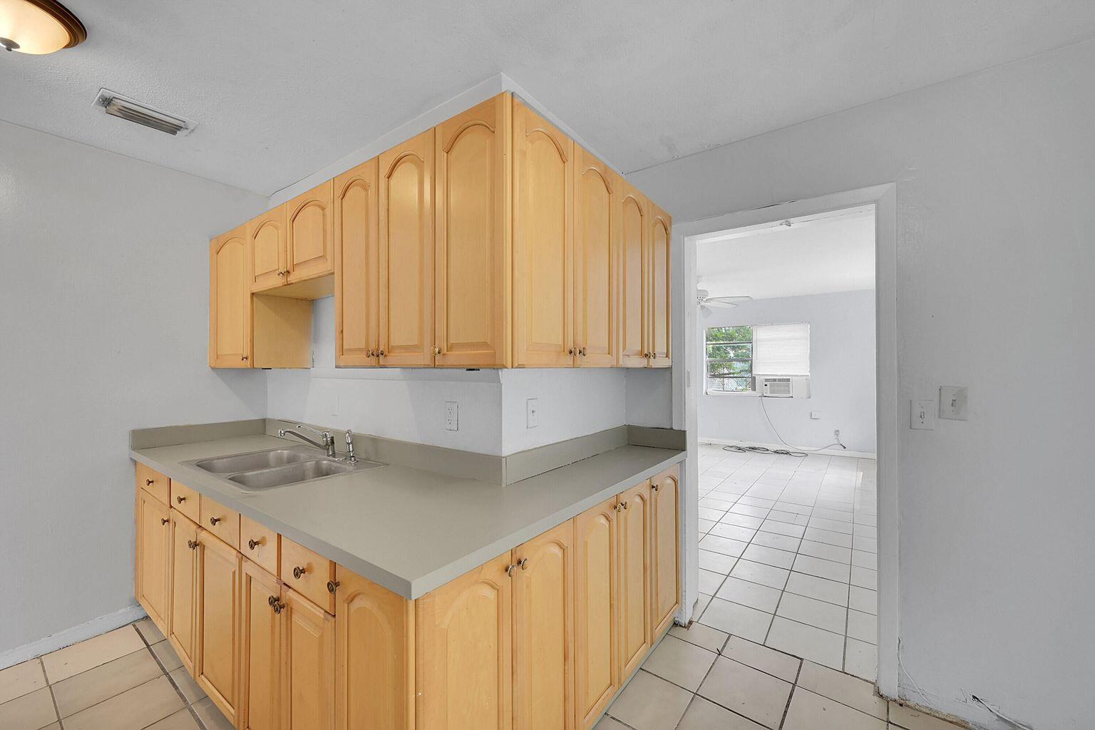 1645 West 31st Street Riviera Beach, FL 33404 - Photo 4 of 20 a kitchen with a sink a stove and a microwave oven