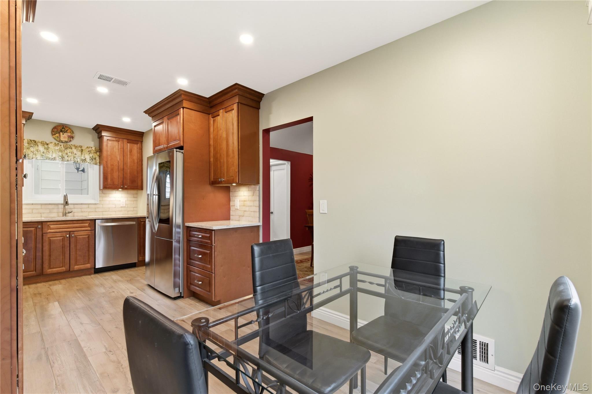 44 Hidden Ridge Drive Syosset, NY 11791 - Photo 8 of 28 a kitchen with stainless steel appliances granite countertop a sink refrigerator and chairs