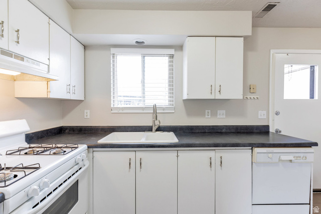 88 West 50 South, Unit J10 Centerville, UT 84014 - Photo 7 of 19 Kitchen featuring white cabinetry and dark countertops