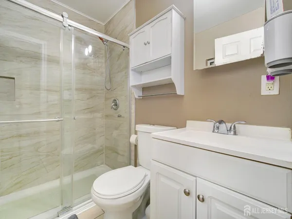a bathroom with a sink a toilet and shower
