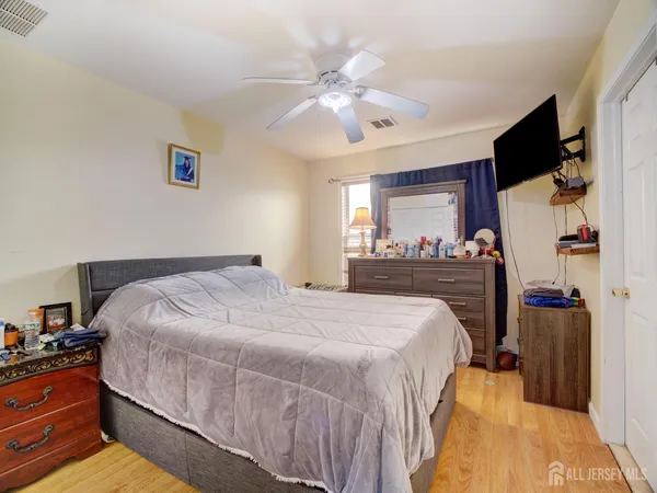 a bedroom with a bed and a flat tv screen on dresser