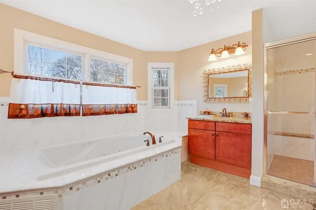 a bathroom with a tub sink and mirror