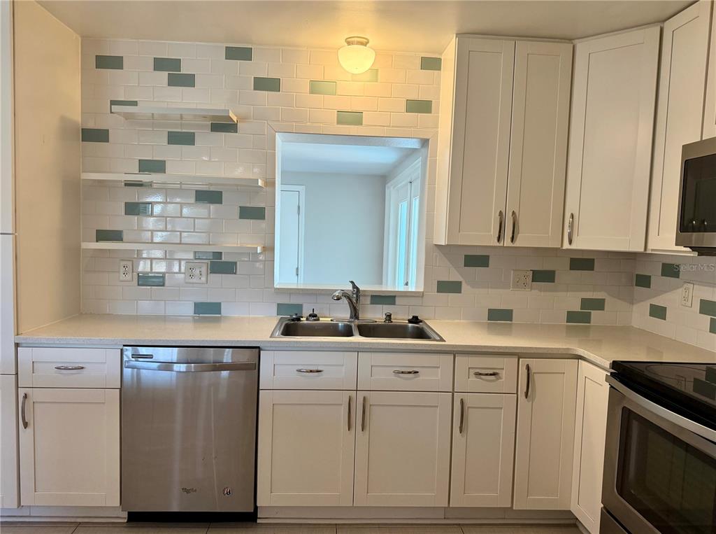 2801 Nancy Street Orlando, FL 32806 - Photo 5 of 39 a kitchen with stainless steel appliances granite countertop a sink and cabinets with wooden floor