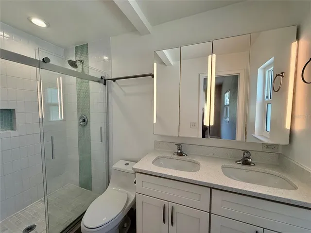 a bathroom with a toilet sink shower and mirror