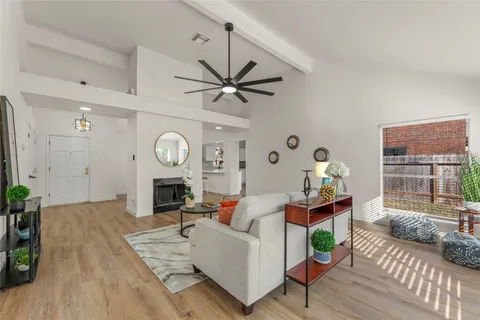 a living room with furniture a fireplace and a large window