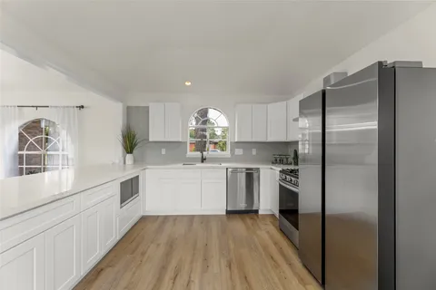 a kitchen with a refrigerator and white cabinets