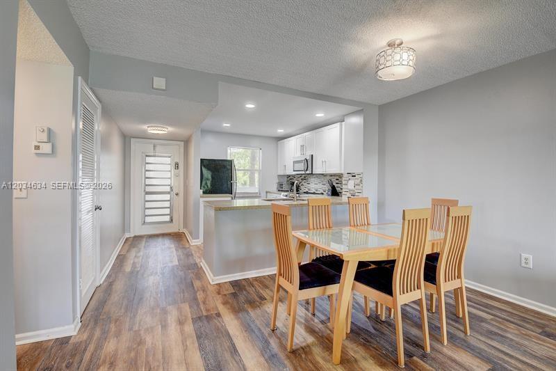 9880 Marina Boulevard, Unit 1516 Boca Raton, FL 33428 - Photo 7 of 32 a view of a dining room with furniture and wooden floor