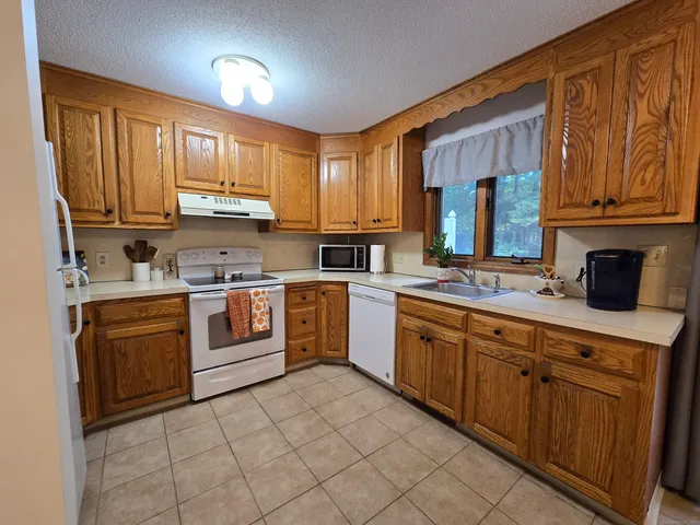 a kitchen with stainless steel appliances granite countertop a stove sink and cabinets