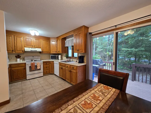 a kitchen with a stove a sink a microwave a dining table and chairs