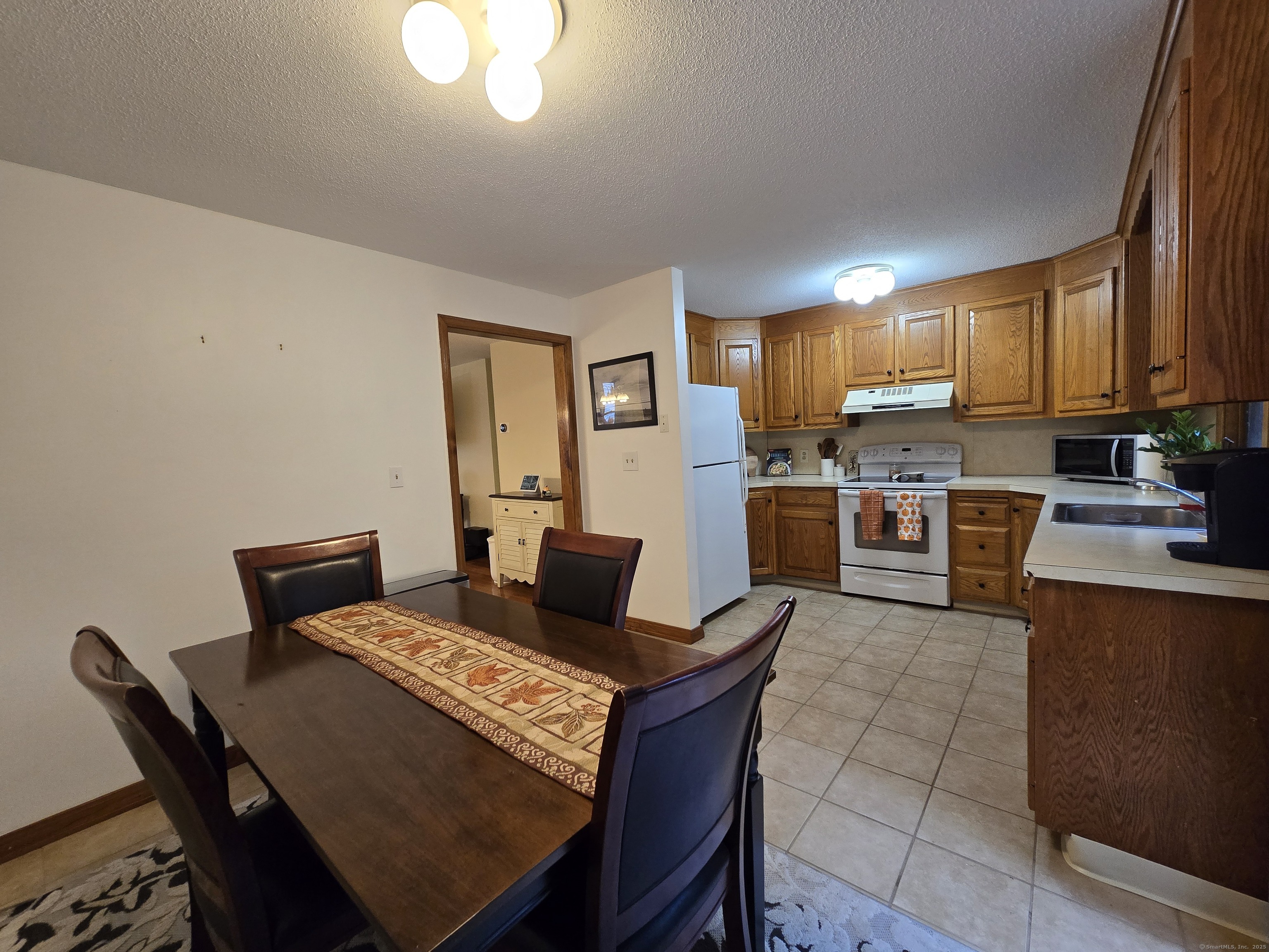85 Oldefield Farms, Unit 85 Enfield, CT 06082 - Photo 15 of 36 a living room with stainless steel appliances furniture a rug and a kitchen view
