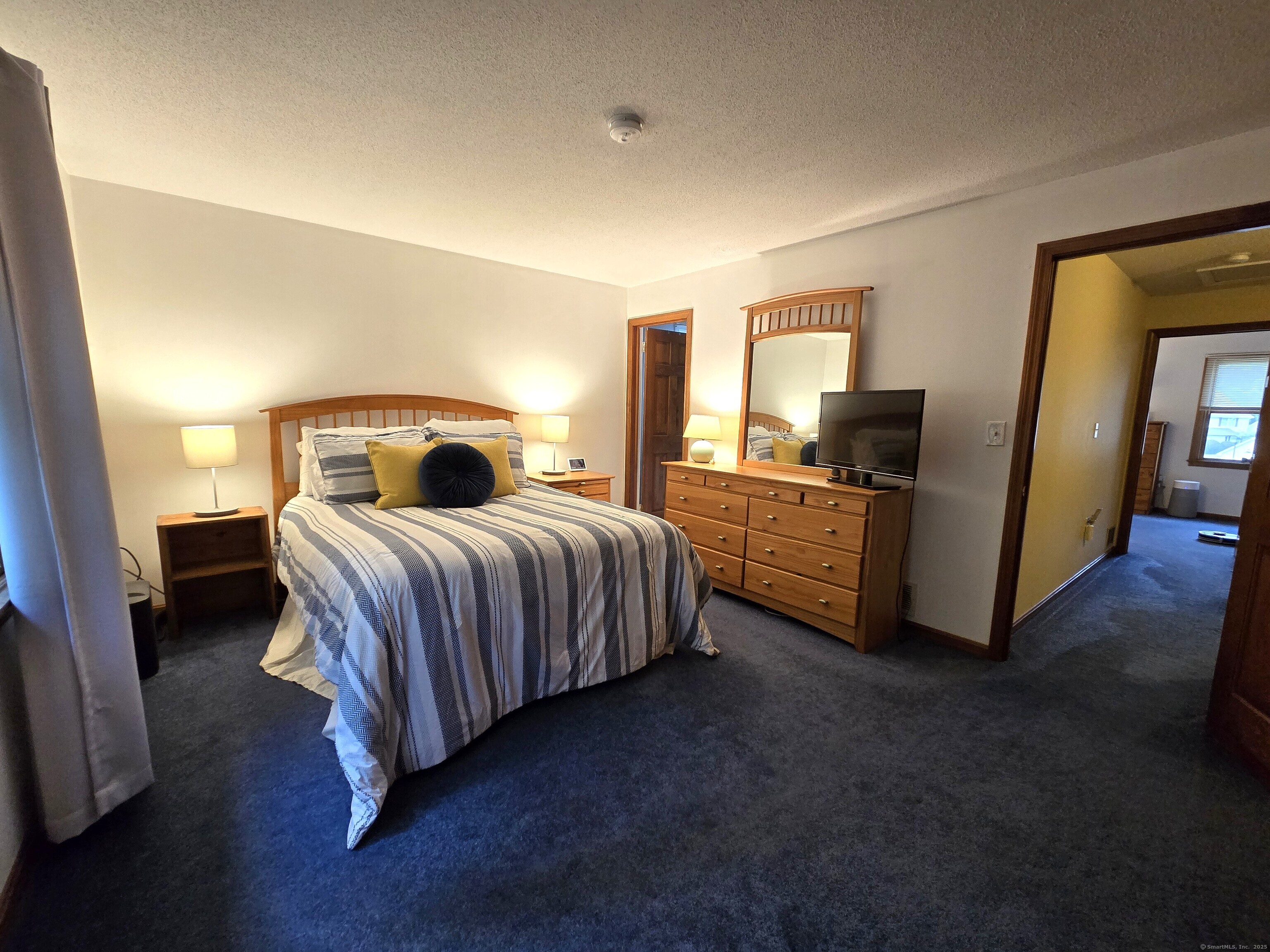 85 Oldefield Farms, Unit 85 Enfield, CT 06082 - Photo 21 of 36 a bedroom with a bed and dresser with mirror