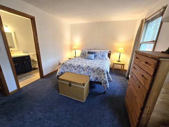 a bedroom with a bed and a mirror on dresser