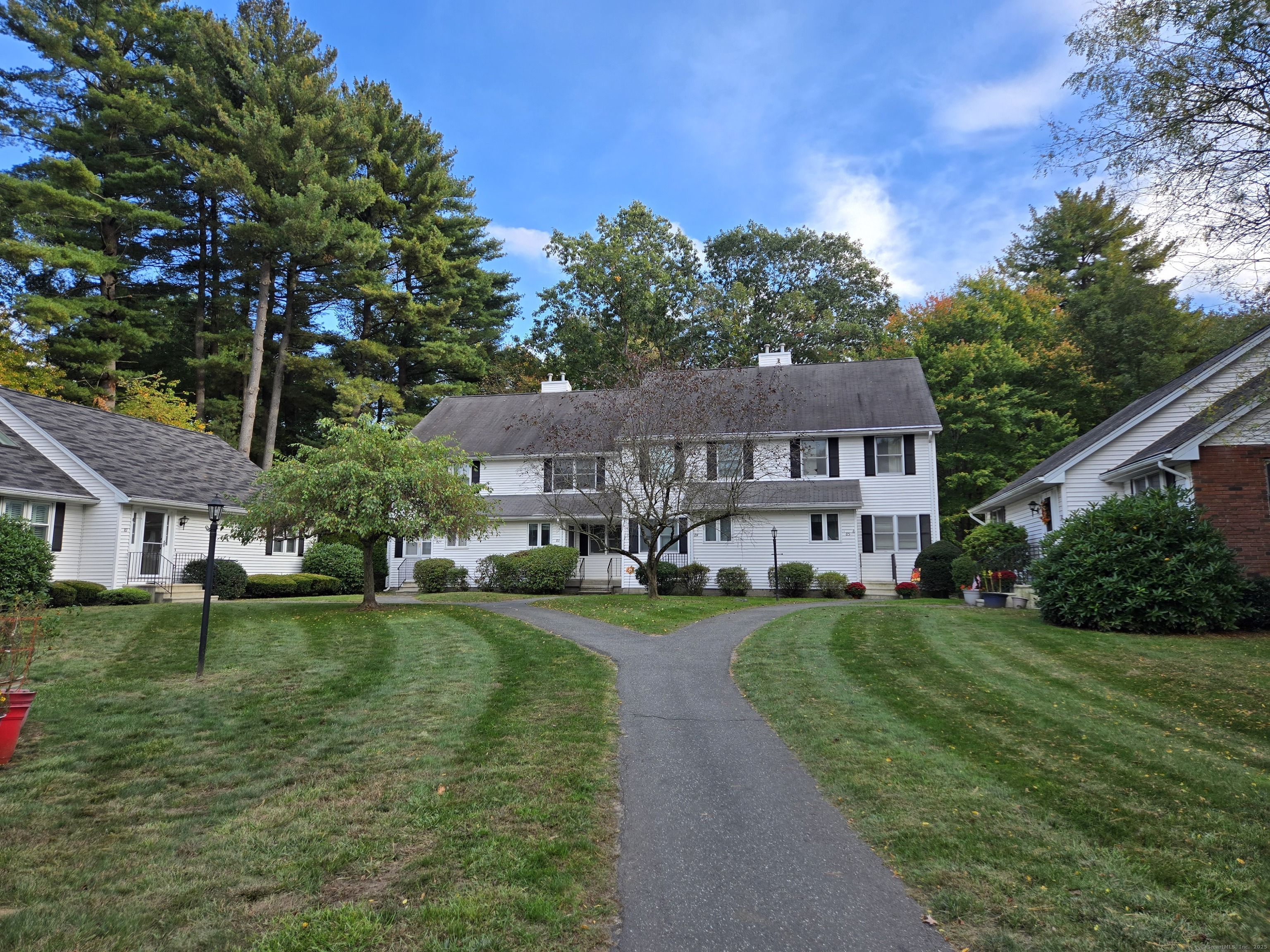 85 Oldefield Farms, Unit 85 Enfield, CT 06082 - Photo 34 of 36 a view of a big house with a big yard and potted plants and large trees