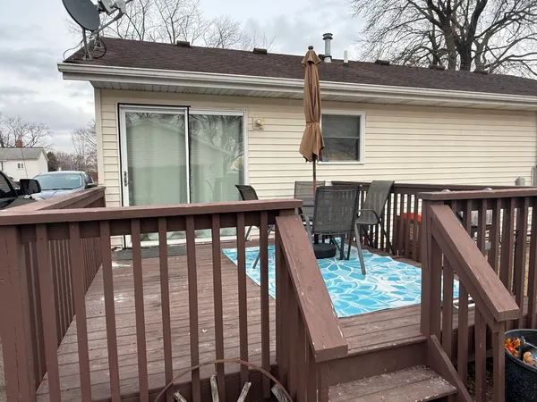 a view of balcony with wooden deck and furniture
