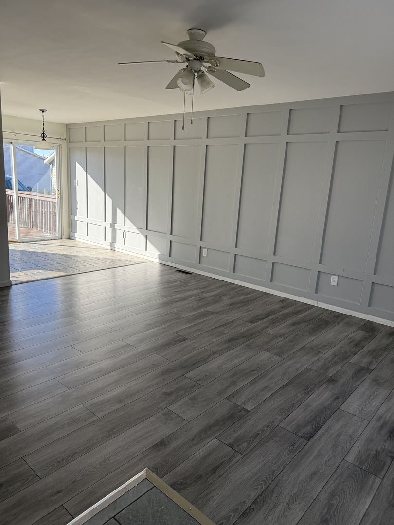 206 South 12th Street Rochelle, IL 61068 - Photo 3 of 14 an empty room with wooden floor fan and windows