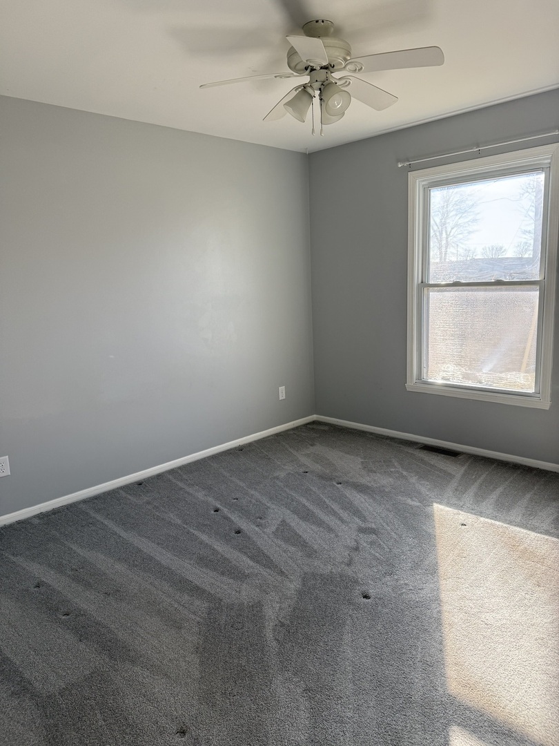 206 South 12th Street Rochelle, IL 61068 - Photo 8 of 14 an empty room with a window and ceiling fan
