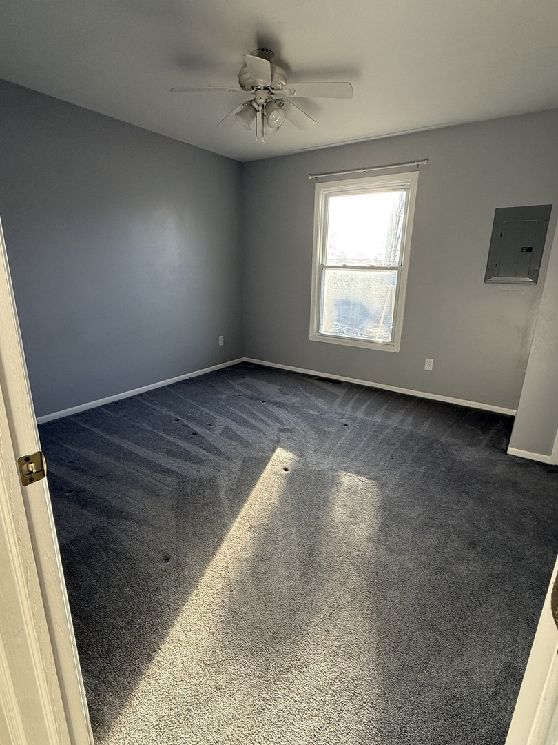 206 South 12th Street Rochelle, IL 61068 - Photo 9 of 14 an empty room with wooden floor fan and windows