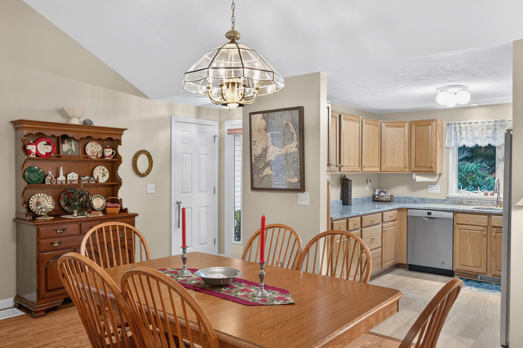 18 Windward Street, Unit 18 Mashpee, MA 02649 - Photo 11 of 34 a kitchen with stainless steel appliances granite countertop a sink a stove a dining table and chairs with wooden floor