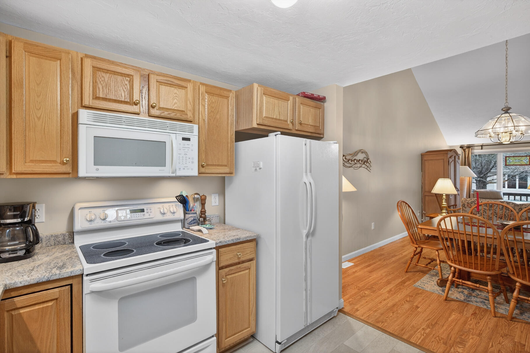 18 Windward Street, Unit 18 Mashpee, MA 02649 - Photo 16 of 34 a kitchen with a refrigerator a stove a dining table and chairs