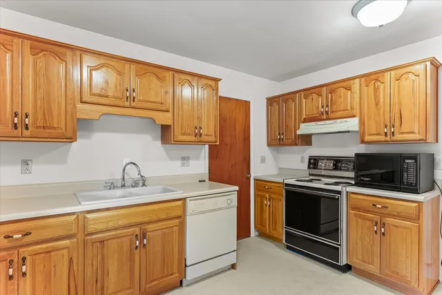 a kitchen with stainless steel appliances granite countertop a refrigerator a stove a sink and a microwave