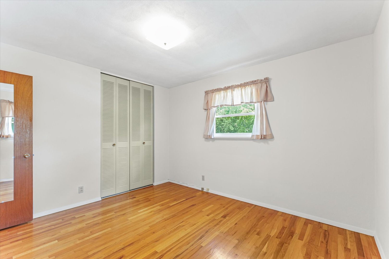 1007 Holiday Drive Champaign, IL 61821 - Photo 21 of 36 a view of empty room with wooden floor and fan
