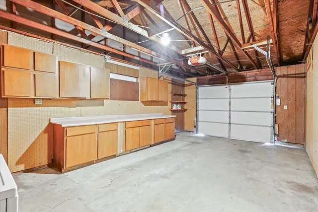 a view of a back yard with brick wall and a large tree