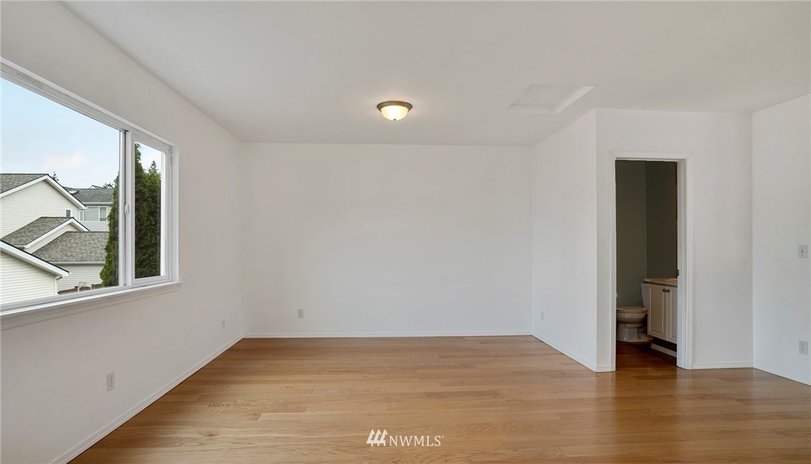 511 Redmond Place Northeast Renton, WA 98056 - Photo 9 of 31 a view of an empty room with wooden floor and a window