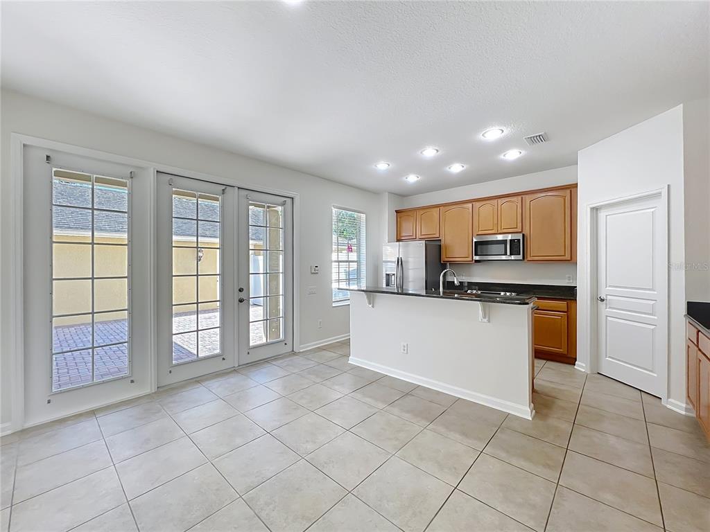 12930 Vennetta Way Windermere, FL 34786 - Photo 4 of 38 a large white kitchen with a stove a sink a microwave and cabinets