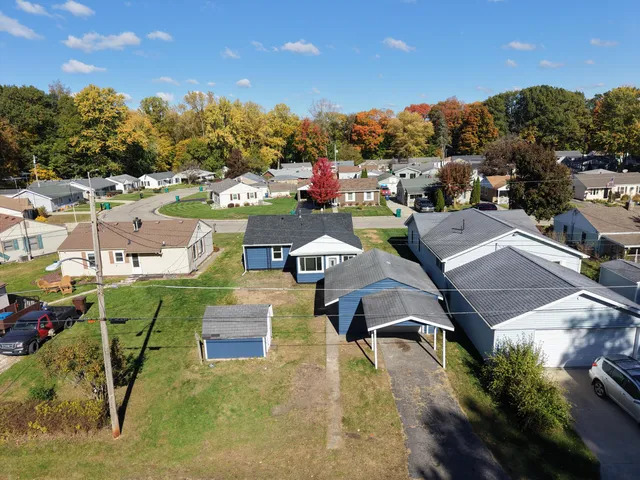 an aerial view of a house with a garden and lake view