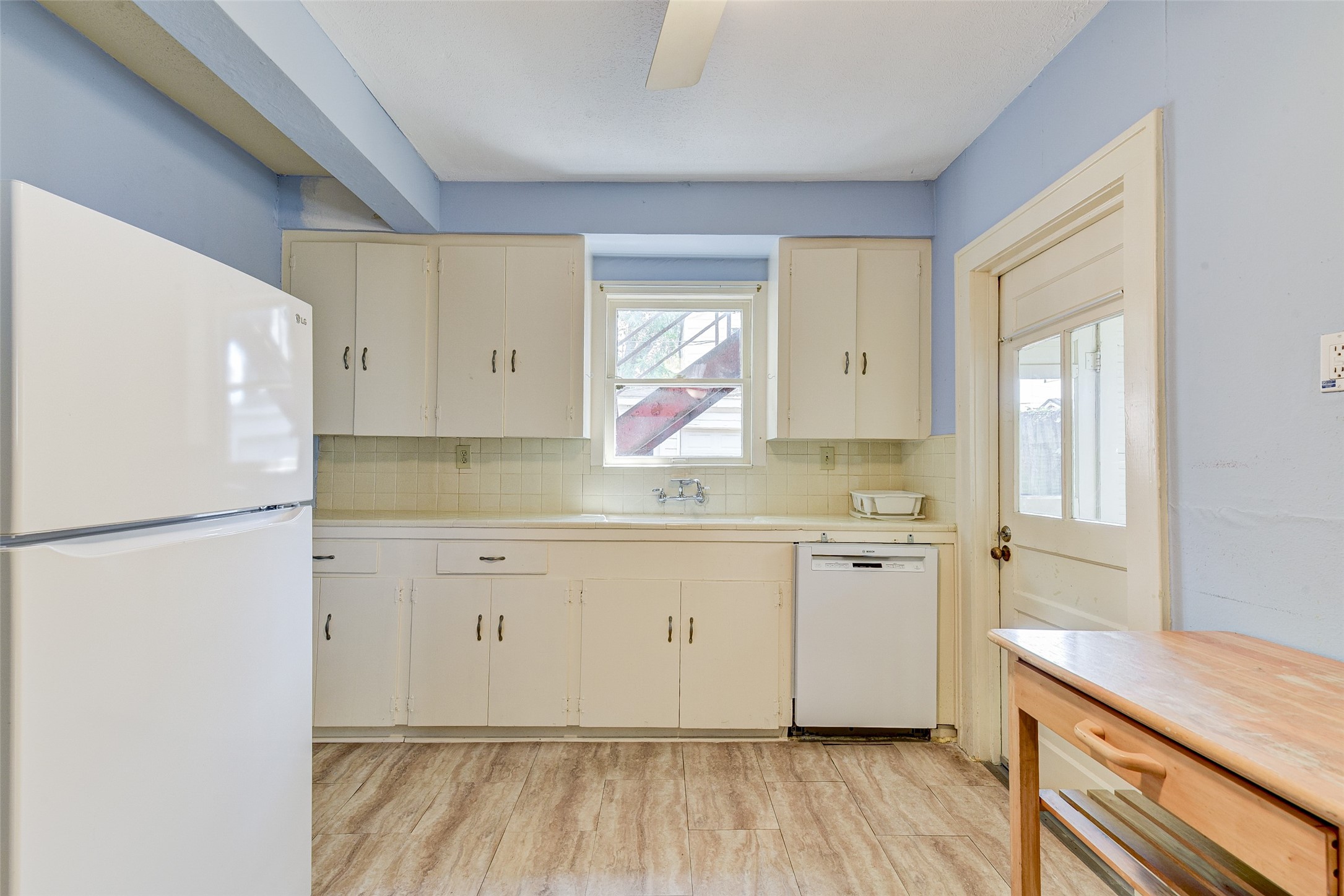 1737 Branard Street, Unit 1 Houston, TX 77098 - Photo 12 of 21 a kitchen with a refrigerator a sink and dishwasher with white cabinets