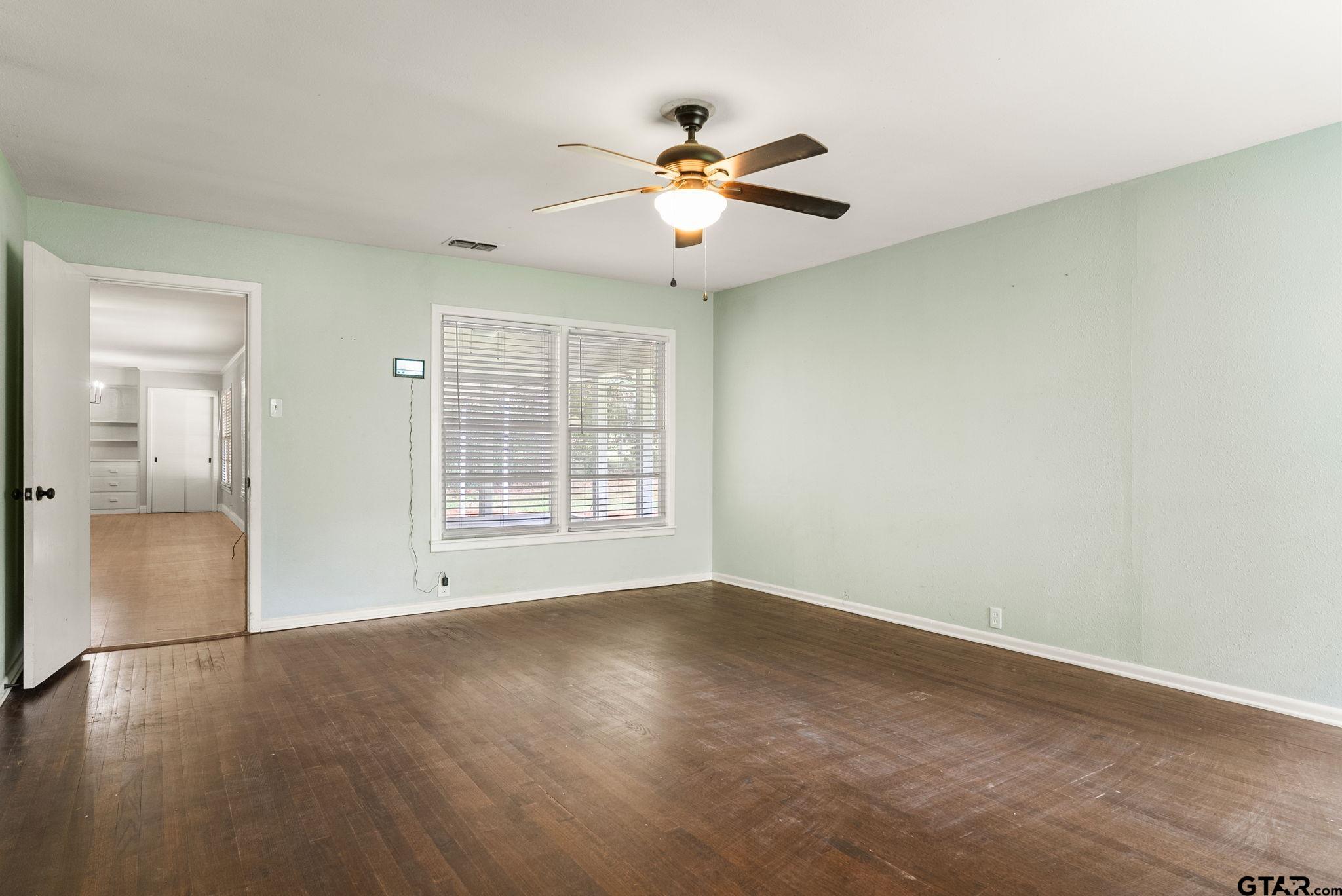 150 Wightman Lane Rusk, TX 75785 - Photo 12 of 38 an empty room with wooden floor chandelier fan and windows