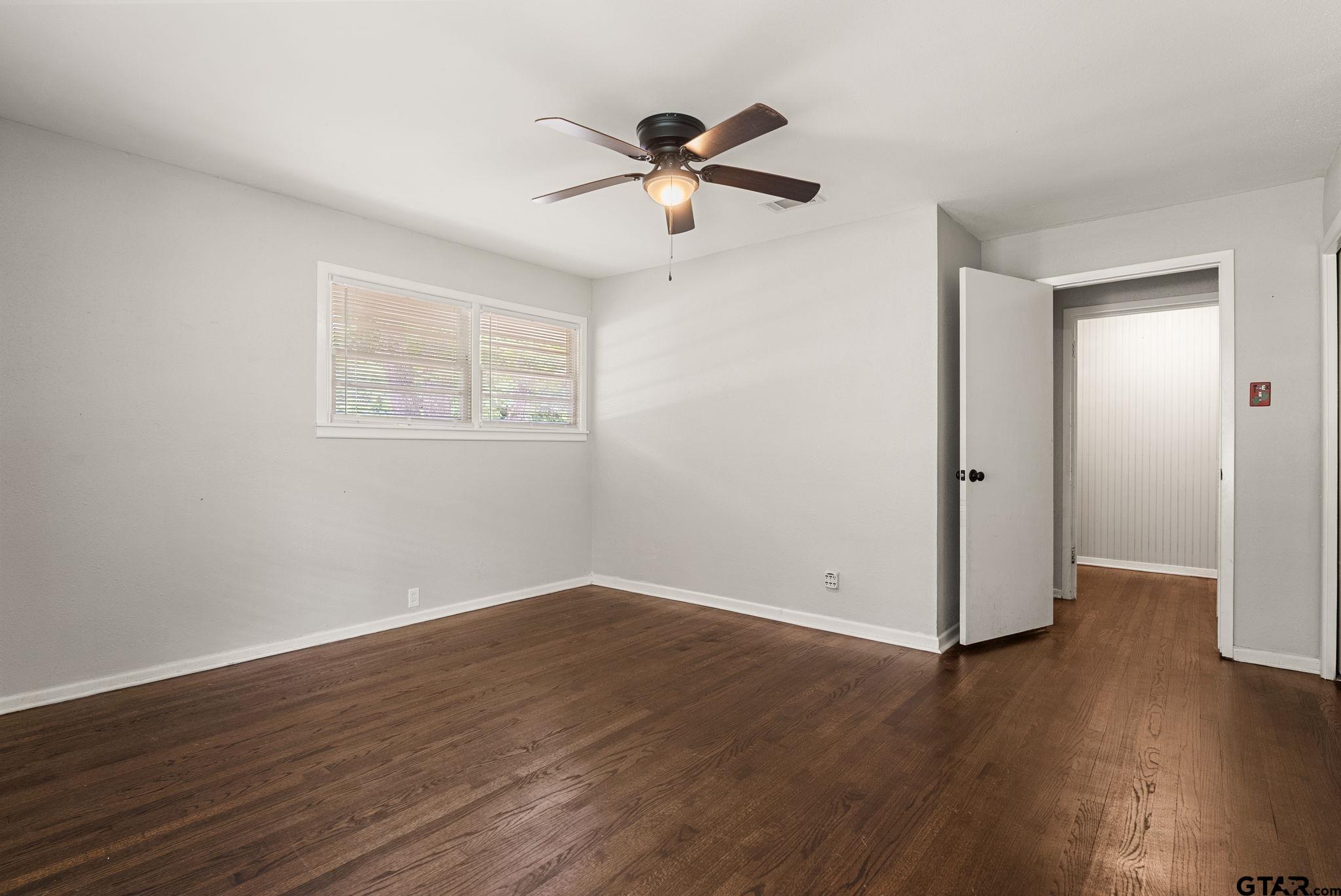 150 Wightman Lane Rusk, TX 75785 - Photo 24 of 38 a view of an empty room with wooden floor and a ceiling fan