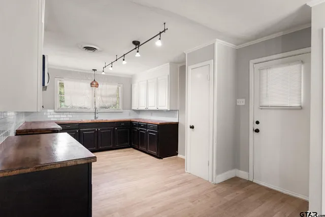 a kitchen with a refrigerator a sink and cabinets