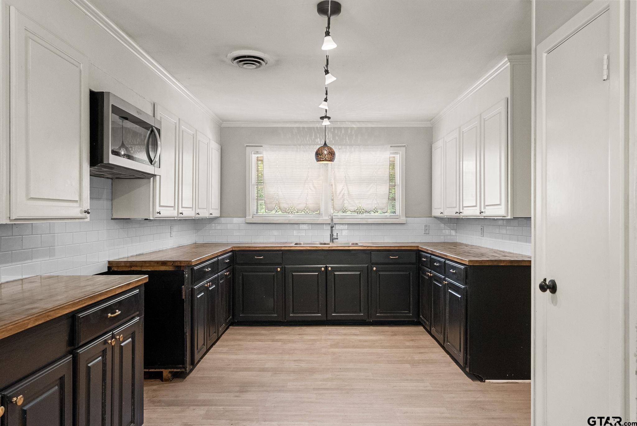 150 Wightman Lane Rusk, TX 75785 - Photo 9 of 38 a large kitchen with granite countertop a stove top oven a sink dishwasher and white cabinets with wooden floor