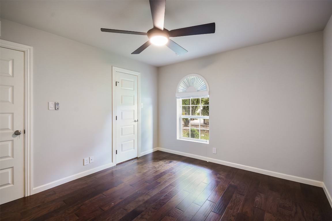 3110 Red River Street, Unit 201 Austin, TX 78705 - Photo 18 of 30 an empty room with wooden floor chandelier fan and windows