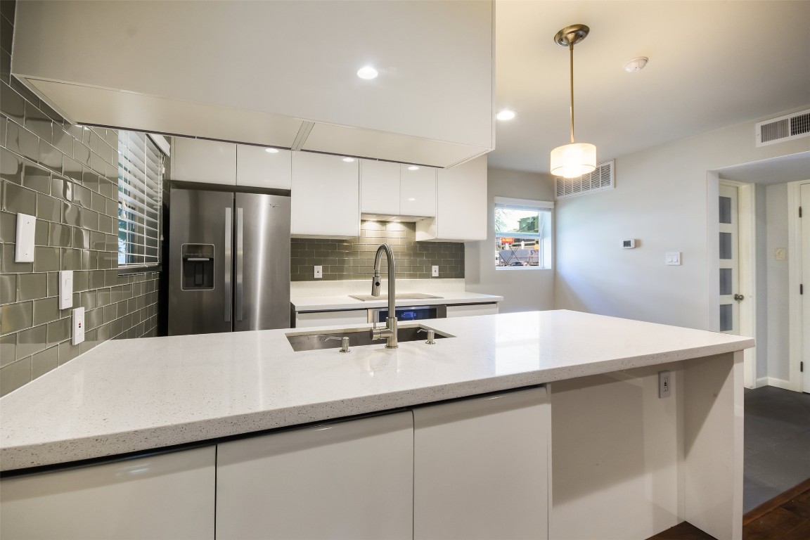 3110 Red River Street, Unit 201 Austin, TX 78705 - Photo 26 of 30 a kitchen with stainless steel appliances a sink a stove a refrigerator and cabinets