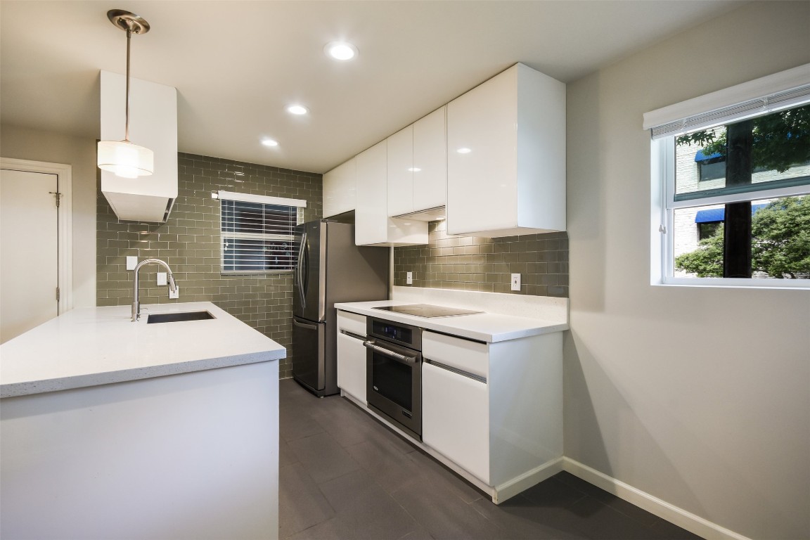 3110 Red River Street, Unit 201 Austin, TX 78705 - Photo 10 of 30 a kitchen that has a sink a stove and a wooden floor