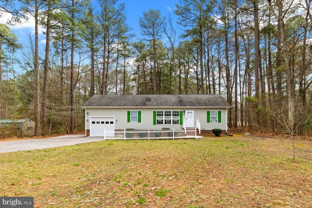 a front view of house with yard and trees around