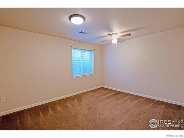 a view of an empty room with a ceiling fan