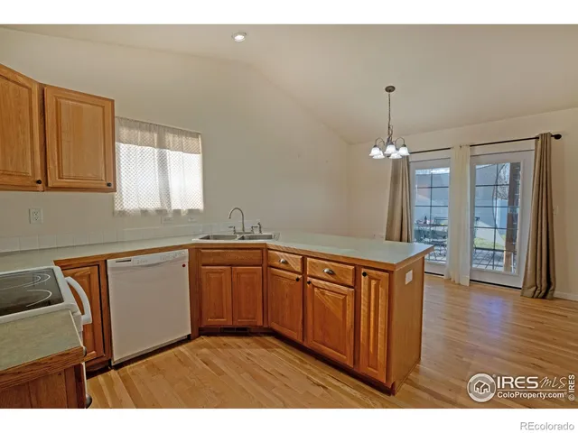 a kitchen with granite countertop a sink cabinets and wooden floor