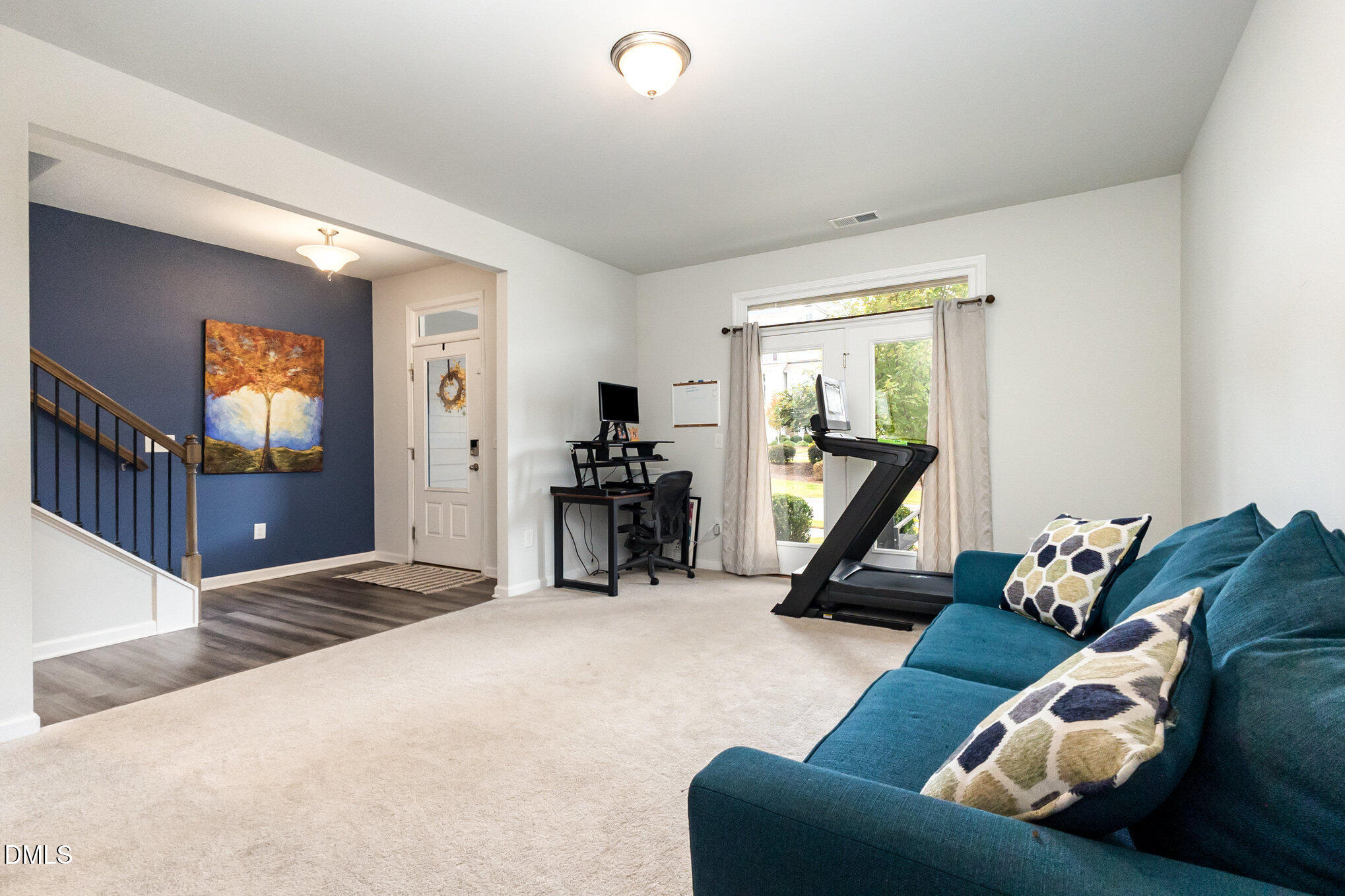 2906 Great Lawn Road Apex, NC 27502 - Photo 17 of 41 a living room with furniture gym equipment and a flat screen tv