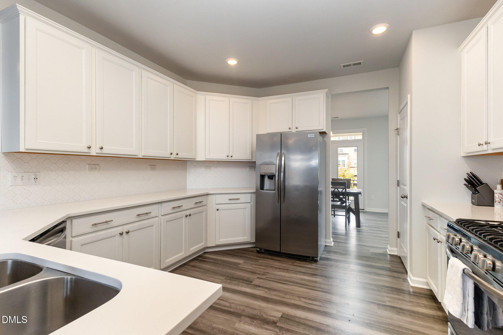 2906 Great Lawn Road Apex, NC 27502 - Photo 5 of 41 a kitchen with stainless steel appliances granite countertop a refrigerator sink and cabinets