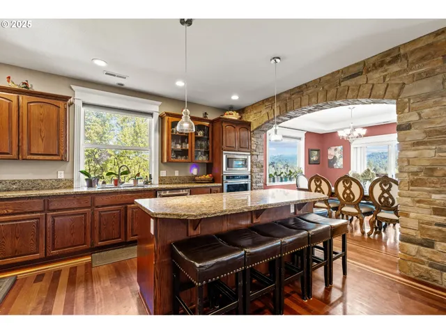 a kitchen with stainless steel appliances granite countertop a sink and wooden cabinets