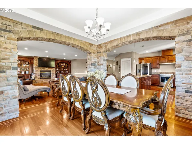 a view of a dining room with furniture a chandelier and kitchen view
