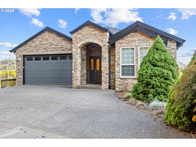 front view of a house with a yard and garage