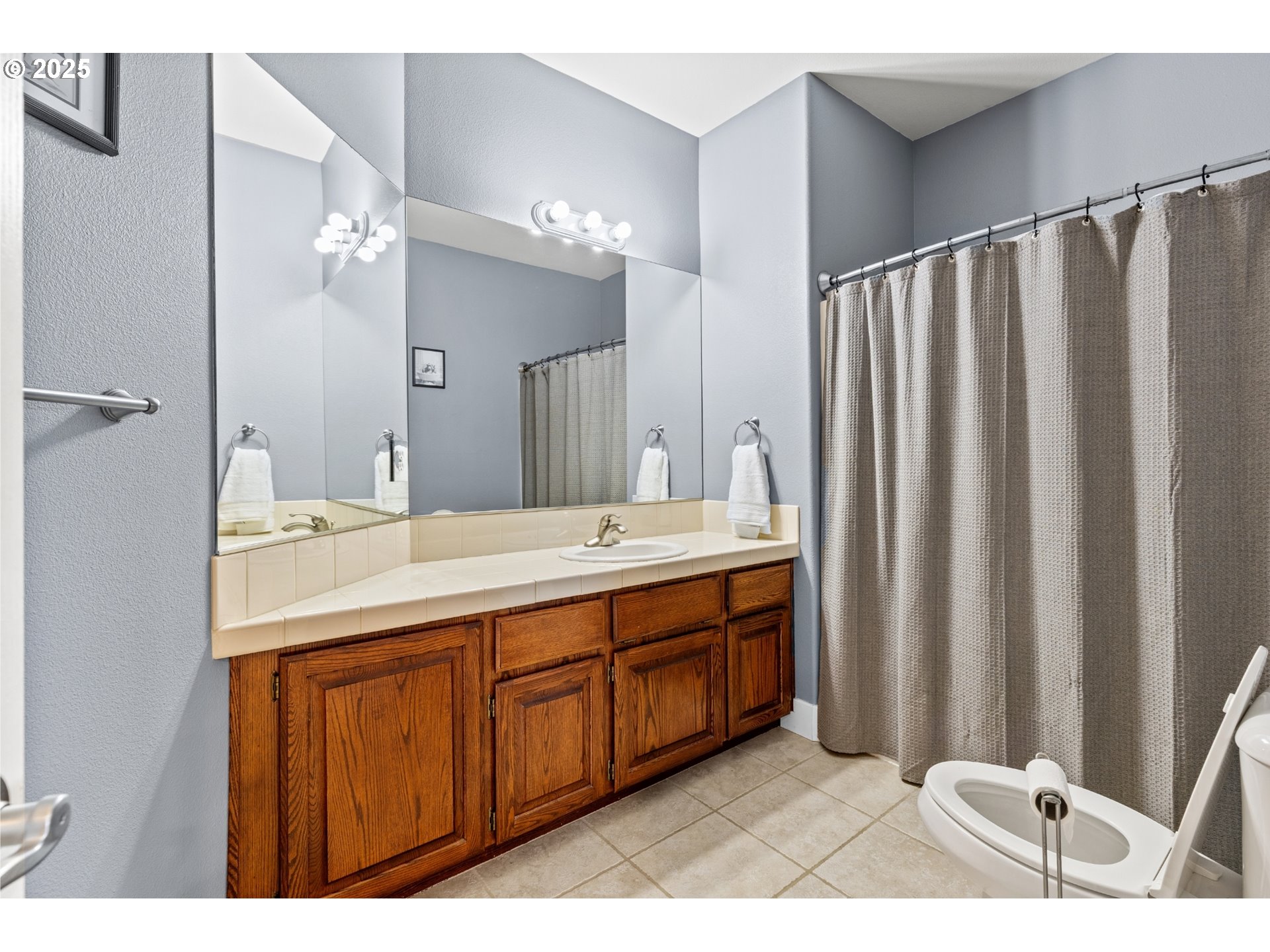 3412 Northwest 1st Street Gresham, OR 97030 - Photo 32 of 40 a bathroom with a double vanity sink a mirror and a shower