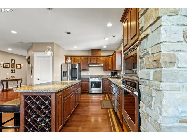 a kitchen with stainless steel appliances kitchen island granite countertop a stove a sink and a refrigerator
